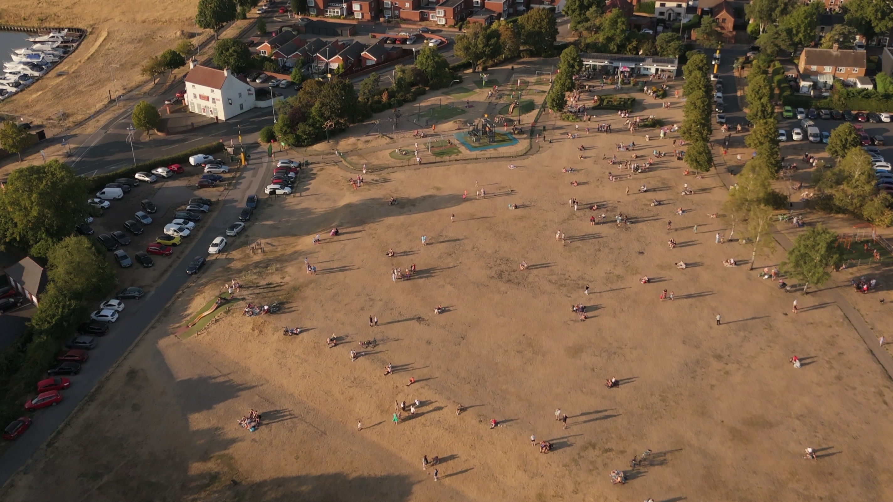 People gathered on Sconce Hill during the partial solar eclipse, with long shadows across the grass